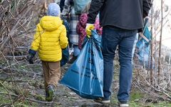 Kinder und Erwachsenen sammeln Müll am Wupperufer