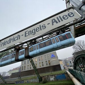 Schwebebahn unter Straßenschild Friedrich-Engels-Allee