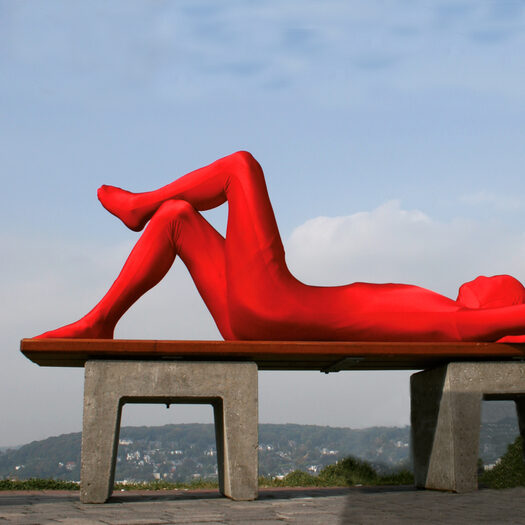Roter Mann liegend auf einer Bank