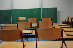 Hochgestellte Stühle in einem Klassenzimmer mit Wandtafel
