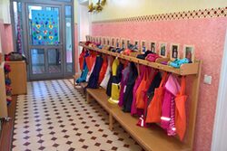 Kleiderhaken mit Kinderkleidung im bunten Flur einer Kindertagesstätte