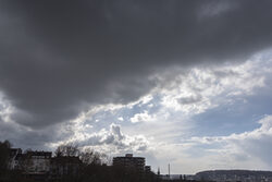 Dunkler Wolkenhimmel mit Stadt-Silhouette