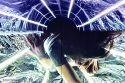 Tanzende Frau auf schimmerndem Untergrund mit Lichtstrahlen