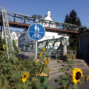 Brücke, Sonnenblumen im Vordergrund, Schild gemeinsamer Fuß+Radweg