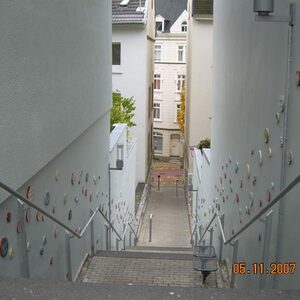 Treppenzug zwischen Häusern, links und rechts mit Punktornamenten verziert