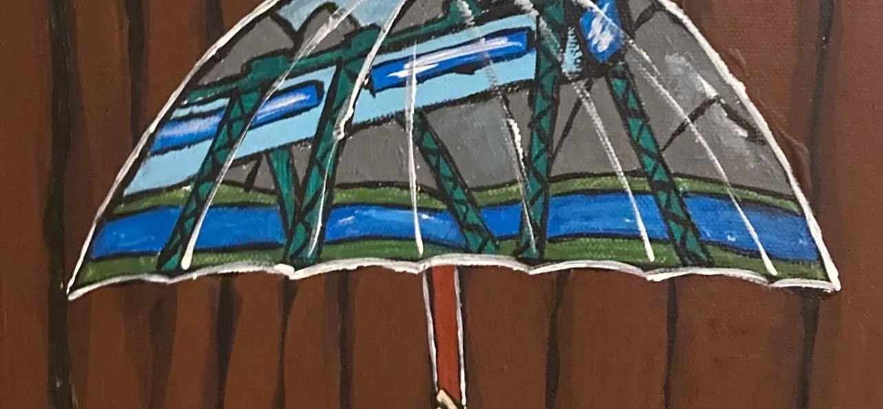 Das Bild zeigt eine Gruppe von Menschen mit unterschiedlichen Hautfarben und Haarstrukturen, die gemeinsam einen großen Regenschirm hochhalten. Auf dem Regenschirm ist die Wuppertaler Schwebebahn abgebildet, während im Hintergrund eine braune Holzstruktur zu sehen ist.