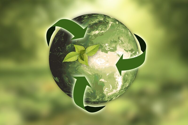 Grüne Erdkugel mit grünen Pfeilen als Symbol für Kreislaufwirtschaft.