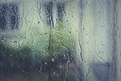 Regen läuft an einer Fensterscheibe runter