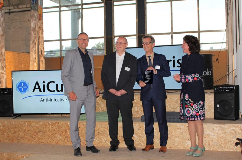 Oberbürgermeister Schneidewind und die Geschäftsführerin der Metropolregion Rheinland überreichen die Auszeichnung an die Geschäftsführer von AiCuris