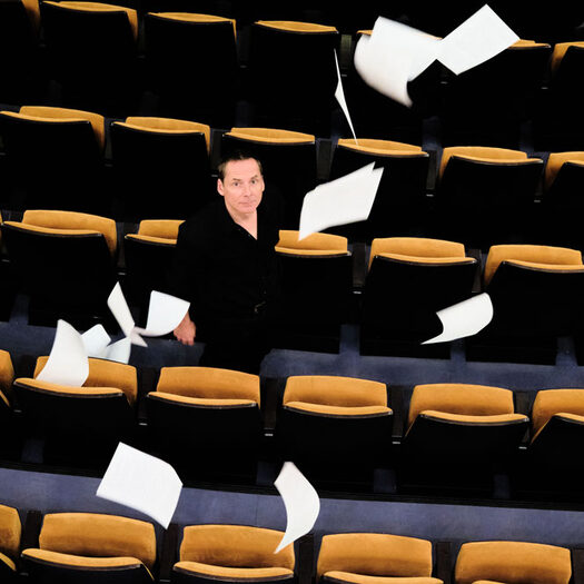 Olaf Reitz steht zwischen den Stühlen im Zuschauerraum der Oper