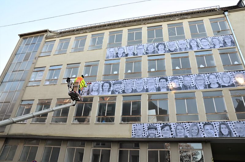 200 Schwarz-Weiß-Porträts hängen an der Fassade der Ex-Bandweberei Kaiser & Dicke in der Gewerbeschulstraße 74 im Wuppertaler Stadtteil Heckinghausen