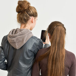 zwei junge Frauen schauen auf ein Handy