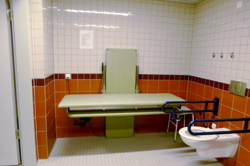 Behinderten-WC, barrierefreie Dusche und elektrisch höhenverstellbare Pflegeliege. Direkter Durchgang zum Bad
