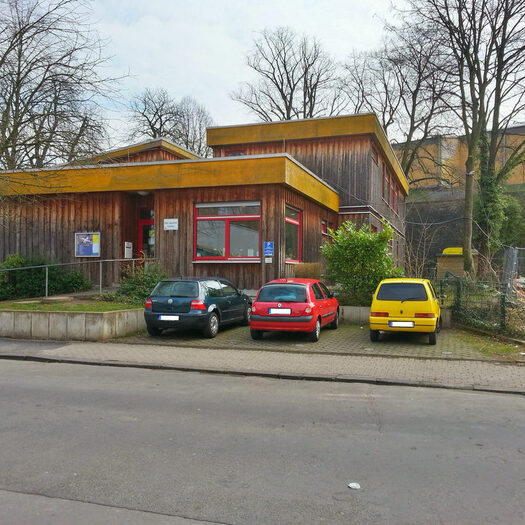 Gebäude des Kinder- und Jugendtreff Arrenberg und Parkplätze mit Autos
