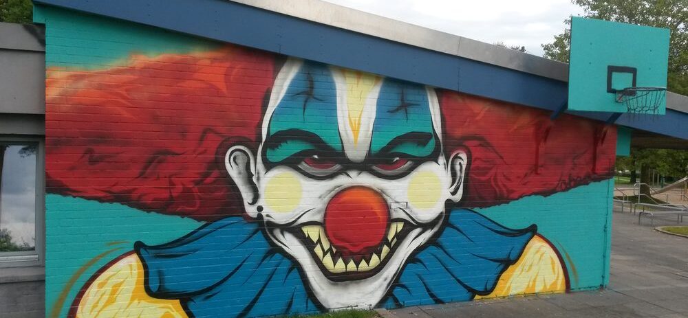 Graffiti Clown auf der Hauswand und Basketballkorb