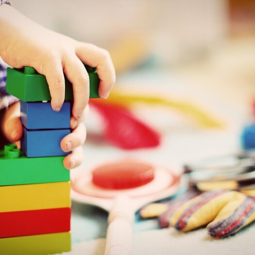 Ein Kind baut einen Turm aus Legosteinen