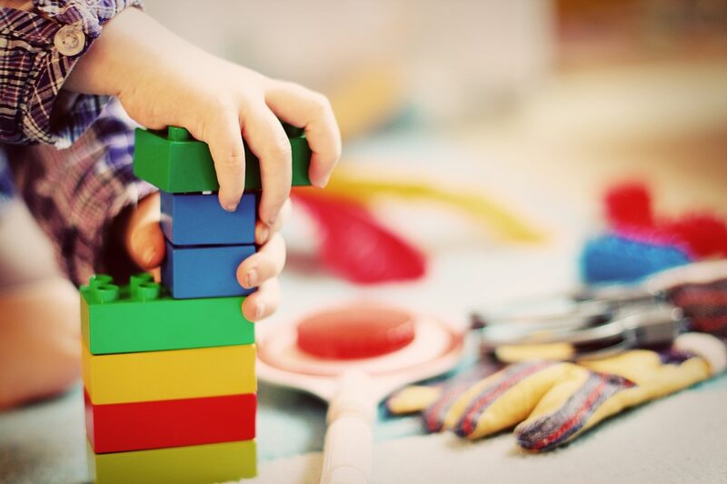 Ein Kind baut einen Turm aus Legosteinen