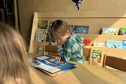 Neue Leseecke für Kinder im Grünen Zoo Wuppertal. Ein Kind schaut sich ein Buch an