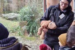 Märchenführung. Zooführer mit einer Handpuppe und Kinder im Vordergrund