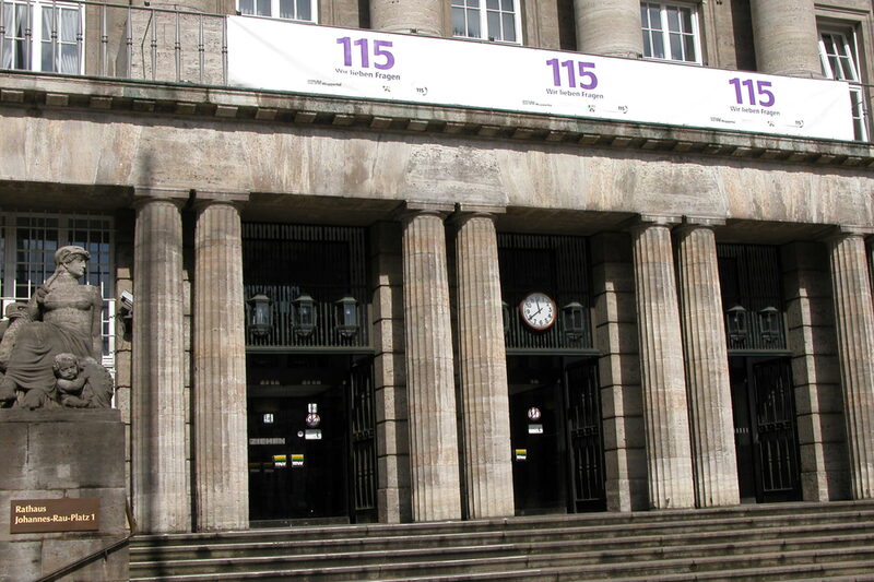 Rathausportal mit einem 115-Banner am Rathausbalkon