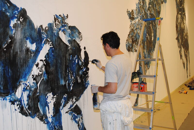 Künstler malt ein Bild in blauer Farbe mit Rodeo-Motiv an die Wand