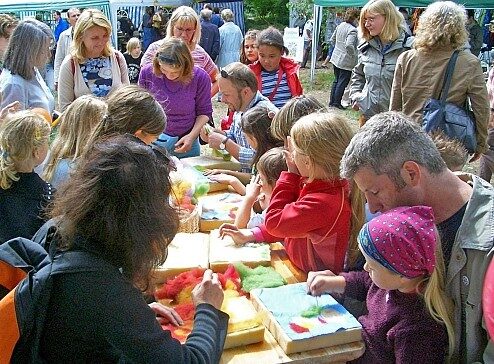 Kindergruppe im Botanischen Garten bastelt an einem langen Tisch
