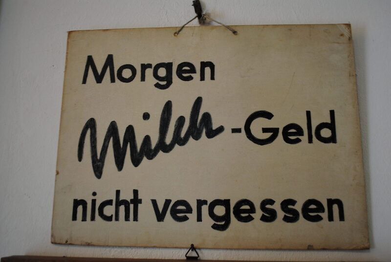 Schild mit der Aufschrift "Morgen Milch-Geld nicht vergessen"