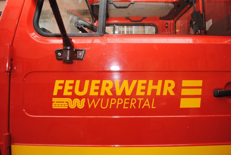 Wenn der Wald brennt, müssen sie ausrücken: Schriftzug "Feuerwehr Wuppertal" auf einer Feuerwehrfahrzeugtür.