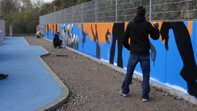 Jugendliche machen die Parkour-Area schön und bemalen eine Betonwand