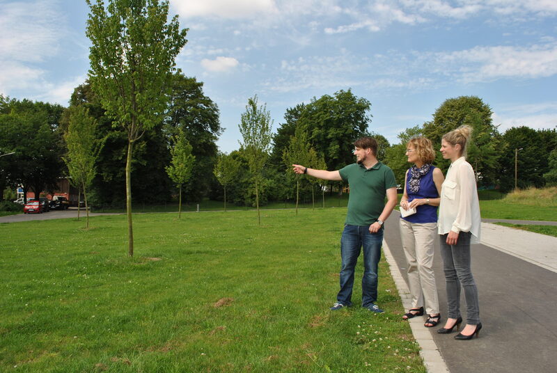 Mattis Ricken (links), Freianlagenplaner bei der Stadt, zeigt Annette Berendes, Ressortleiterin Grünflächen und Forsten (Mitte), und Ina Temme, Deutsche Reihenhaus (rechts), den Blick auf die gegenüberliegenden Hänge.
