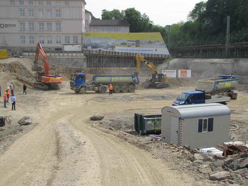 Blick in die Baugrube Döppersberg, in der mehrere Baufahrzeuge bei der Arbeit sind.