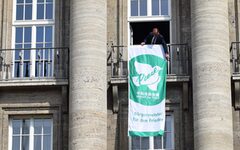 Oberbürgermeister Andreas Mucke richtet die Flagge am Rathaus