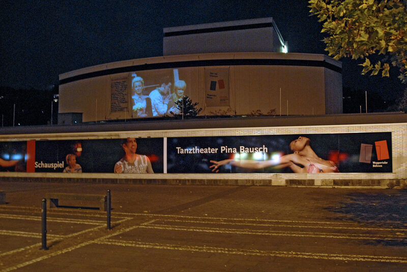 Schauspielhaus bei Nacht mit beleuchteten Tanztheater-Bannern