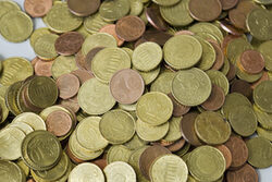 Euromünzen liegen lose aufgeschüttet auf weißer Unterlage