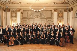 Gruppenbild des Sinfonieorchesters mit Instrumenten im Stadthallensaal