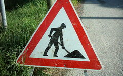 Schild am Straßenrand gibt Hinweis auf Bauarbeiten