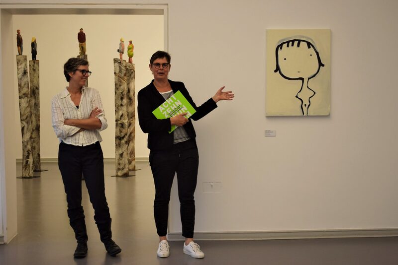 Dr. Bettina Pausch, Leiterin des Wuppertaler Kulturbüros, erläutert zusammen mit der Künstlerin Birgit Pardun die Zeichnung "Punkt, Punkt, Komma, Strich, fertig ist die Frau nich"
