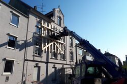 Ein THW-Teleskoplader sichert mit einer Holzkonstruktion die Fassade des einsturzgefährdeten Gründerzeithauses in dr Beyeröhde