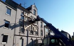 Ein THW-Teleskoplader sichert mit einer Holzkonstruktion die Fassade des einsturzgefährdeten Gründerzeithauses in dr Beyeröhde