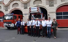 Besucher und Gastgeber stehen vor einem Feuerwehrwagen in Liegnitz