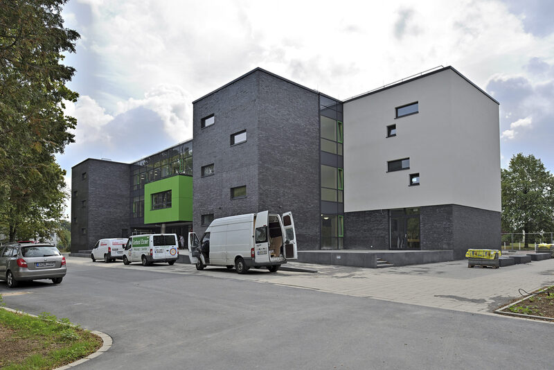 Die Grundschule in der Nathrather Straße wird nach den Sommerferien 2019 wiedereröffnet. Das Foto zeigt die weiß-grüne Fassade des Gebäudes.