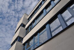 Außenaufnahme zeigt das Gymnasium am Kothen mit blauen Fensterrahmen und weißer Fassade