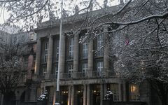 Front des Rathauses im Winter mit schneebedeckten Lindenästen im Vordergrund