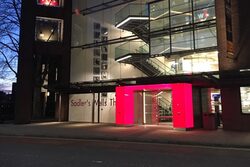 Eingang des Theaters Sadler's Wells in London mit rot beleuchtetem Entree