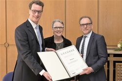 NRW-Verkehrsminister Hendrik Wüst, Christine Fuchs und Oberbürgermeister Andreas Mucke bei der Urkundenübergabe