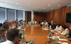 Teilnehmer der Gespräche in Berlin sitzen an einem großen ovalen Besprechungstisch