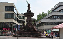 Neptunsbrunnen in Elberfeld mit Geschäften im Hintergrund