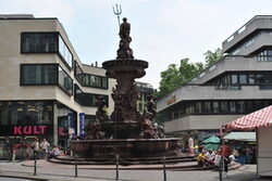 Neptunsbrunnen in Elberfeld mit Geschäften im Hintergrund