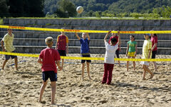 Kinder spielen Beachvolleyball im Sand