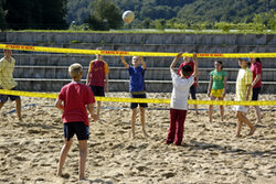 Kinder spielen Beachvolleyball im Sand